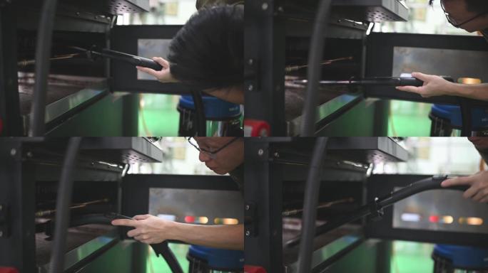 亚裔中国工匠在用真空吸尘器吸尘器烘烤后清理锅炉内的剩余物