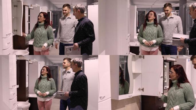 经过短暂的参观后，在商店浴室陈列室，年轻夫妇向一位销售人员展示了他们想买的药柜