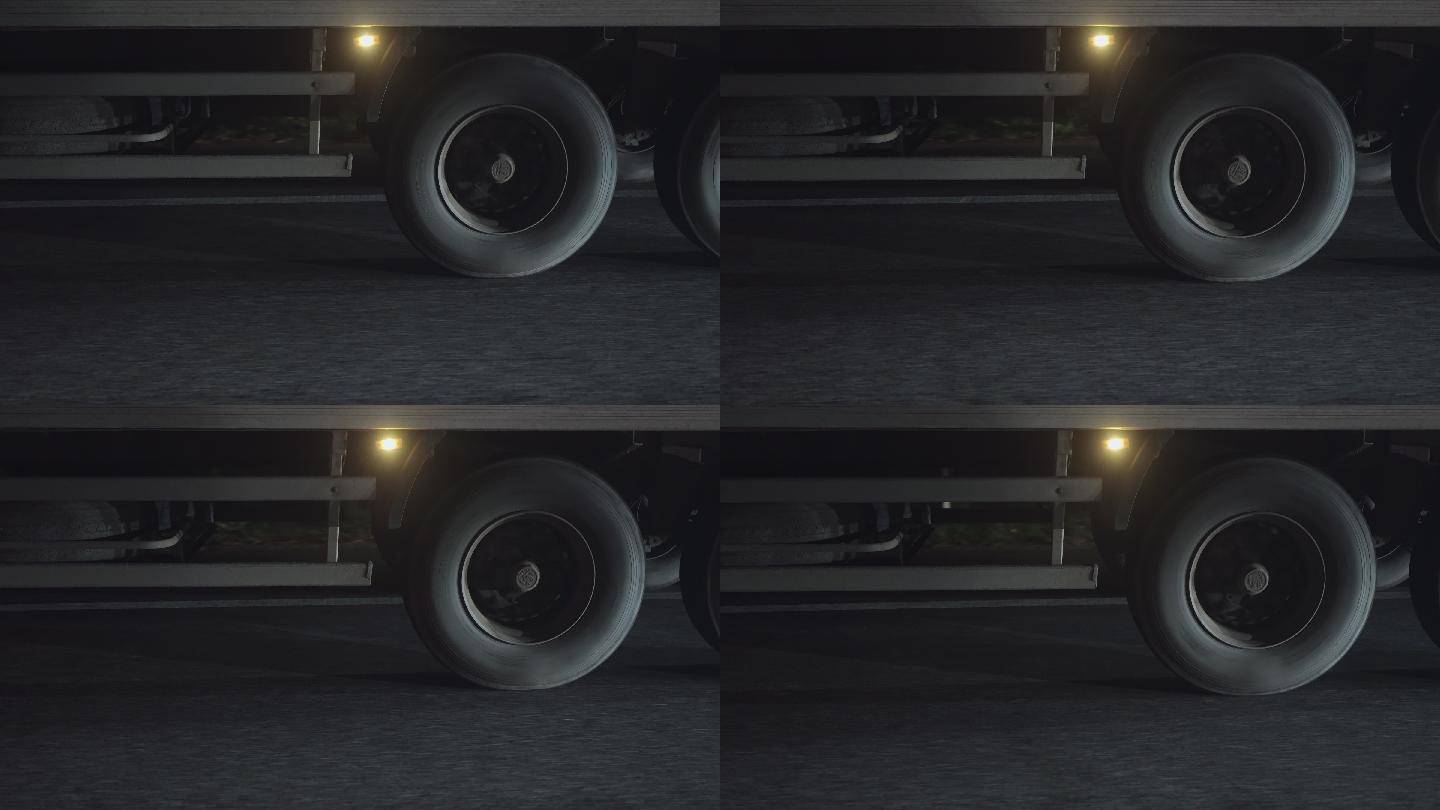 夜间高速公路上行驶的半挂车车轮的特写镜头。