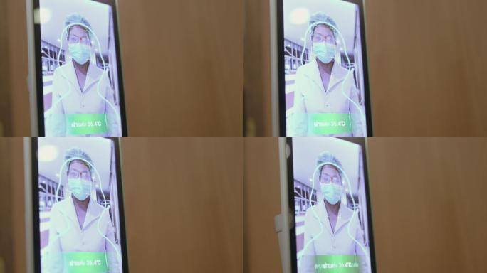 封闭式护士走向摄像头，在智能触摸屏温度计上聚焦和测量她的体温-库存视频