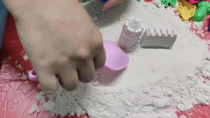 用塑料块打动砂玩耍