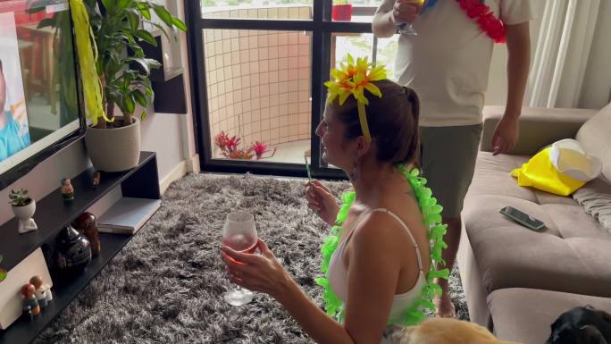 年轻女子在家与朋友视频聊天庆祝巴西狂欢节