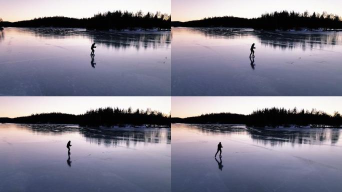 4K空中无人机视角青少年男孩在广袤宁静的冰冻湖面上滑冰，实时库存视频