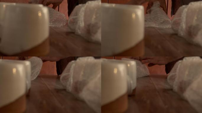 一名男子用泡泡纸包裹杯子的4k视频片段