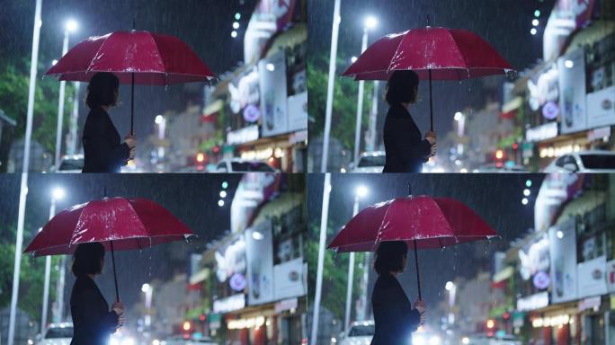 在雨中，一位亚洲妇女撑着雨伞。