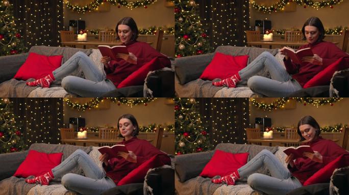 一位棕色头发、穿着红色毛衣和牛仔裤的年轻迷人的女士坐在一间舒适的圣诞装饰房间里，读着一本有趣的书