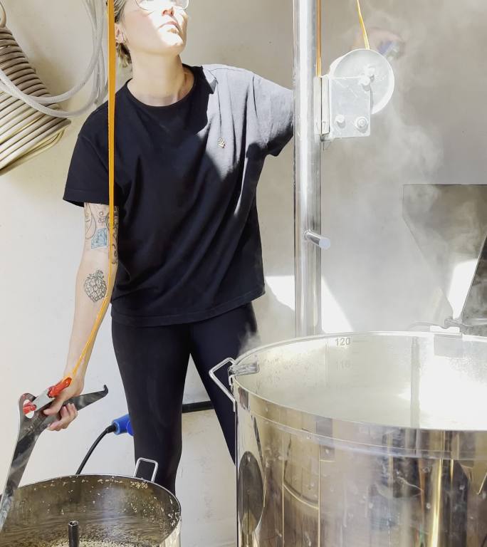 工艺啤酒企业家在啤酒酿造过程中拔出大麦罐
