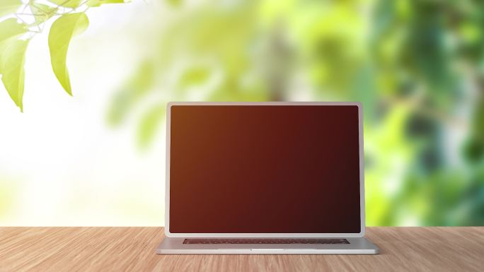 黑屏笔记本电脑站在绿色背景的桌子上。