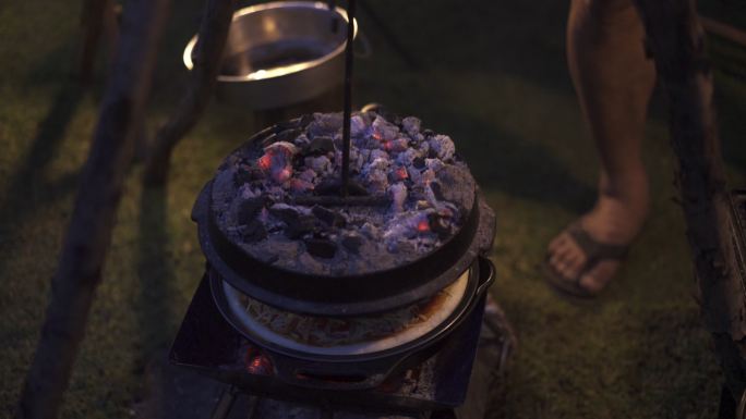 露营的亚裔中国人用木柴和大锅烧鸡