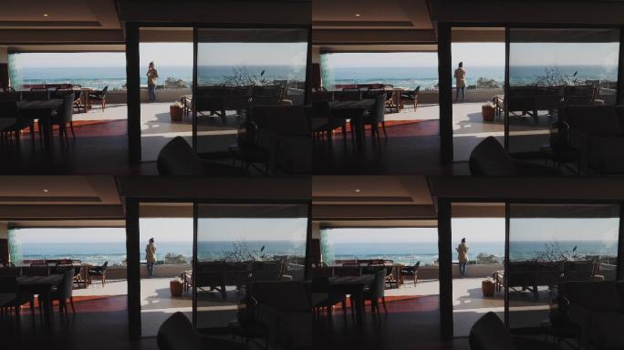 在风景如画的海景豪华露台上，女人在智能手机上聊天