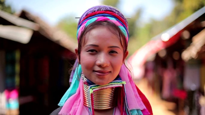 一位脖子上戴着传统金属环的妇女在村里的一家织布厂工作