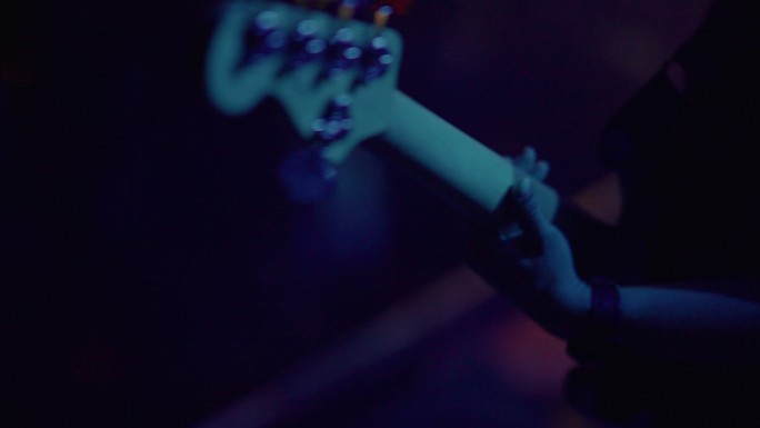 摇滚乐队的亚洲吉他手在夜总会现场演奏吉他。