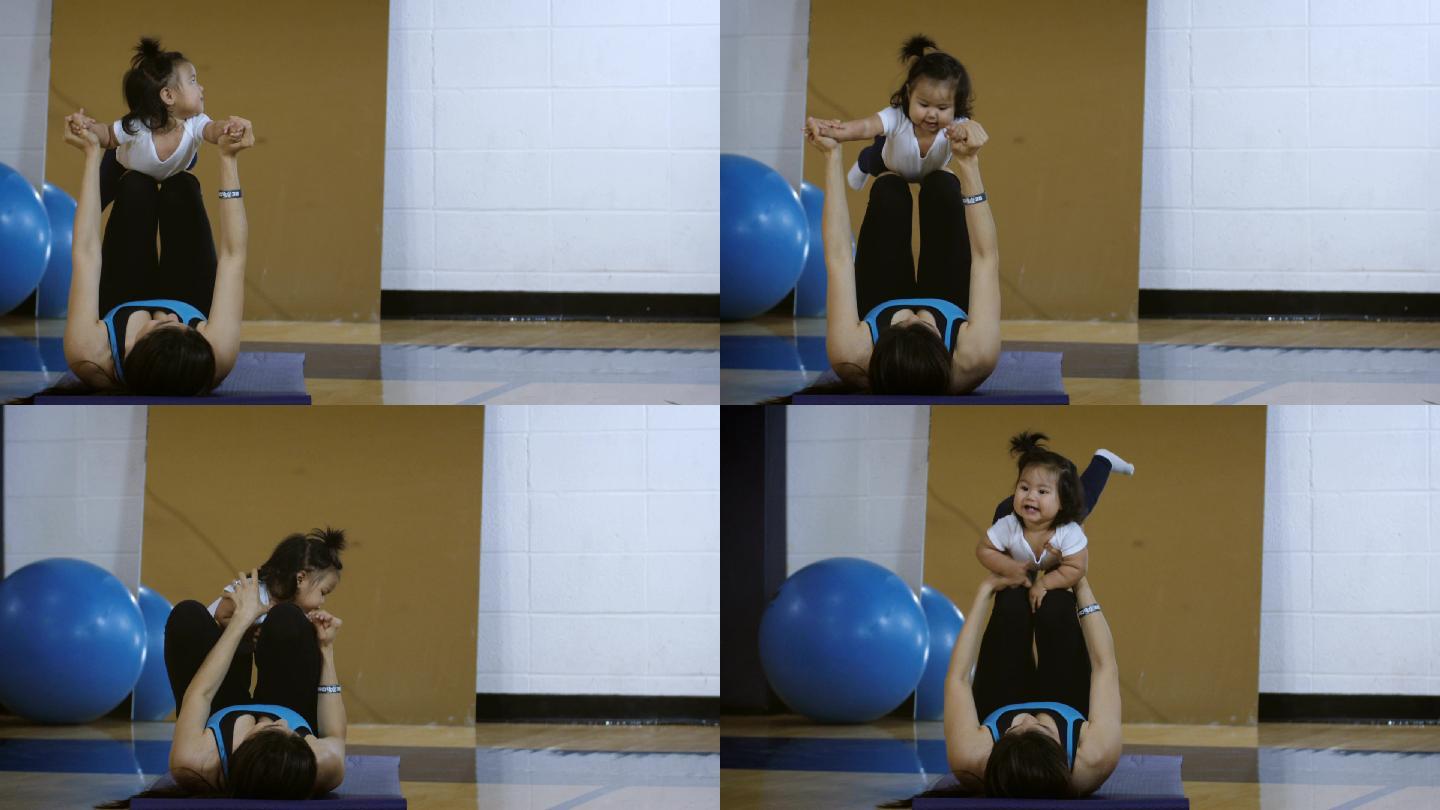 年轻母亲带着婴儿在健身房锻炼