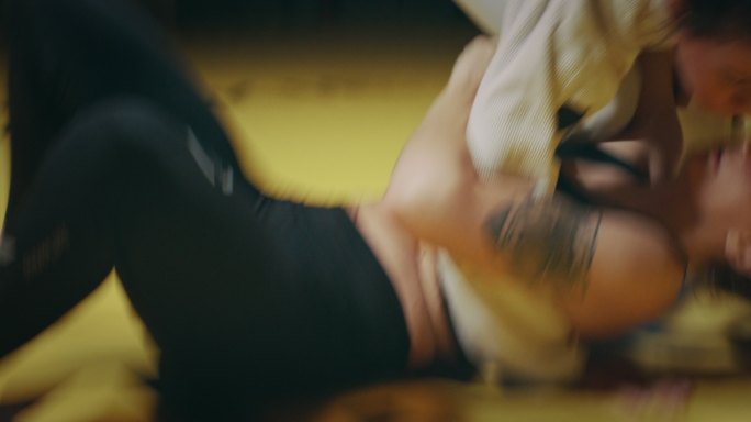 女子MMA拳击手训练。在垫子上投掷