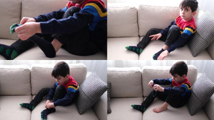 可爱的小男孩试着穿袜子。