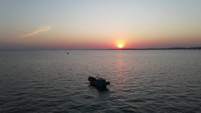 4k航拍夕阳下汪洋大海中的一艘渔船