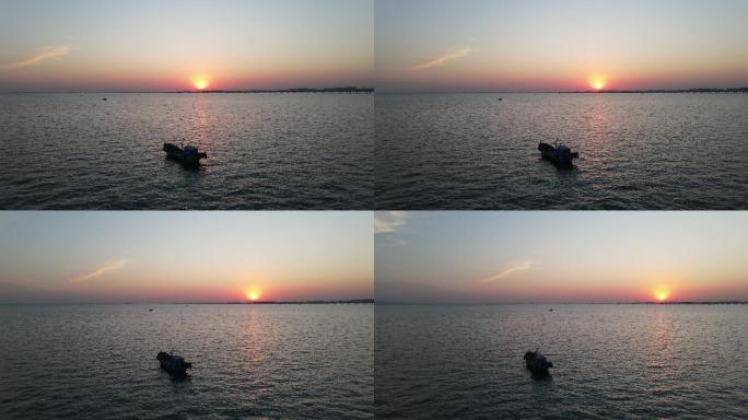 4k航拍夕阳下汪洋大海中的一艘渔船
