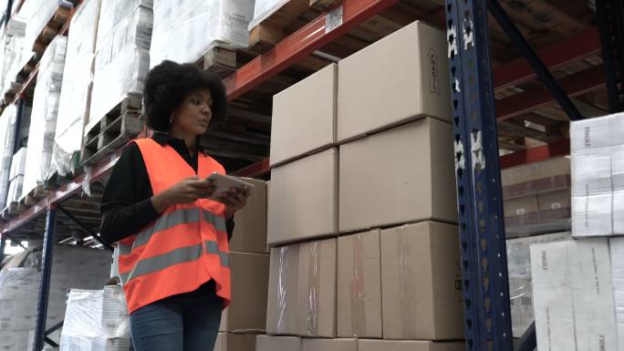 非洲女工人在仓库使用数字平板电脑