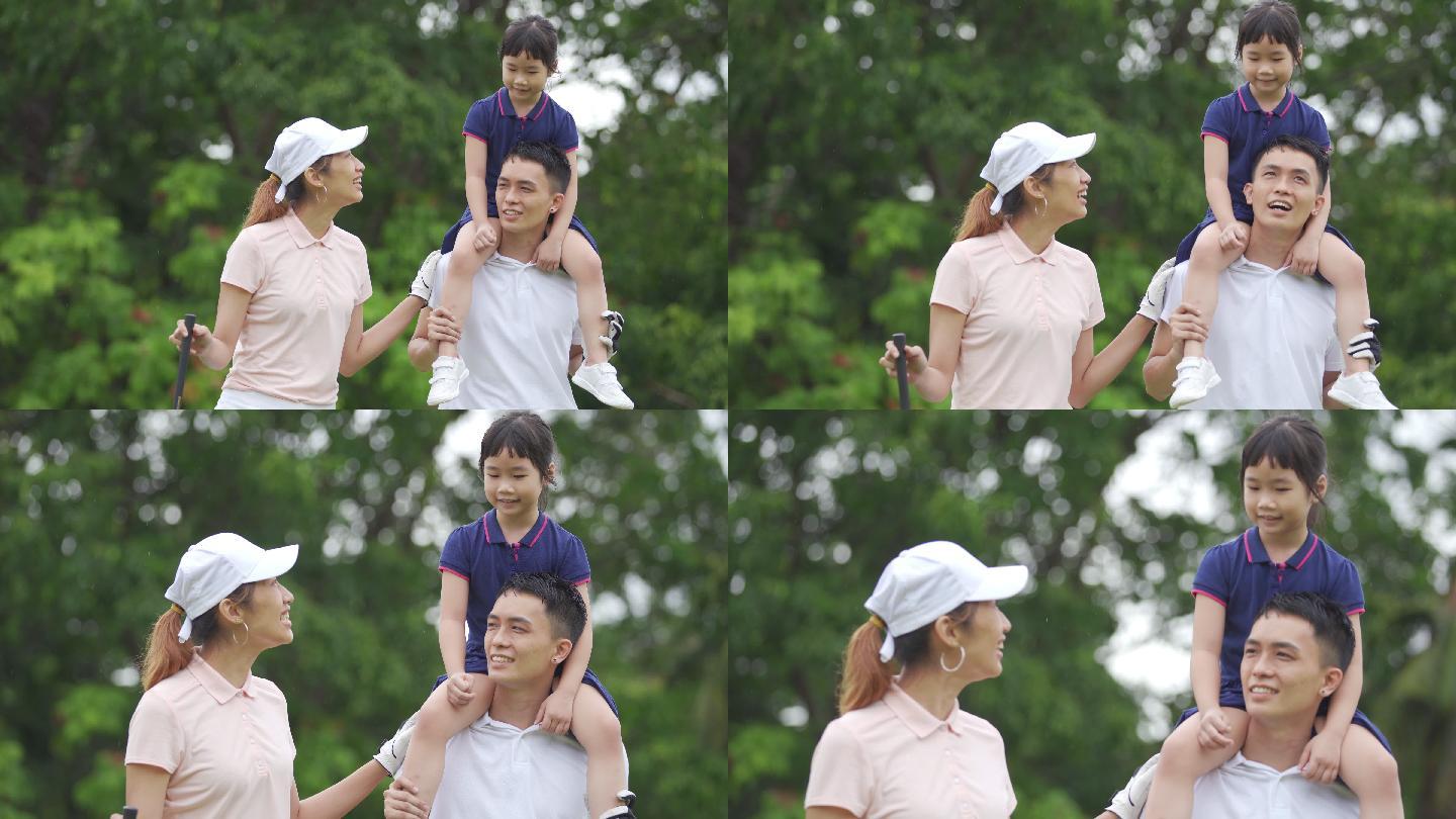 快乐的亚裔中国高尔夫夫妇与女儿在高尔夫球场建立友谊
