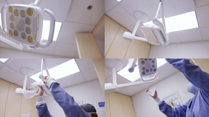 在牙科诊所的检查室里，一名50多岁的拉丁裔医护人员戴着口罩，在牙科灯的把手上盖上干净的塑料罩