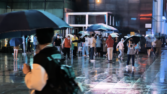 城市下雨夜晚雨中打伞过马路逛街人群