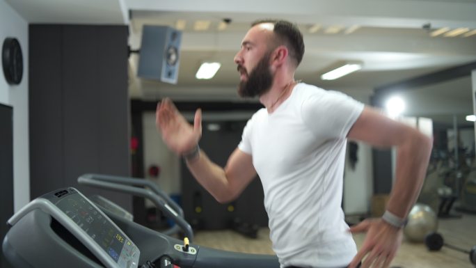 健身男子在跑步机上进行有氧训练