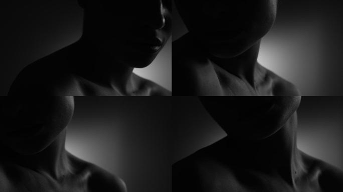 一个裸露肩膀的女孩的头部特写镜头缓慢移动。黑白视频。