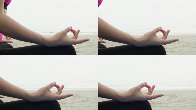 在瑜伽垫上做瑜伽和冥想的女人。早上，亚洲女性在海天多云的海滩上穿着运动服。