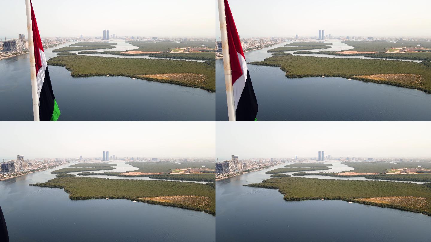 阿联酋国旗和酋长国哈伊马角空中城市景观地标性天际线矗立在阿联酋北部的红树林和小溪之上