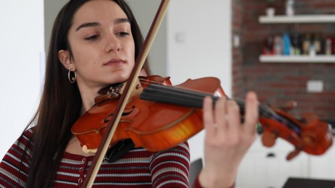 这位年轻的女艺术家每天在家练习拉小提琴。