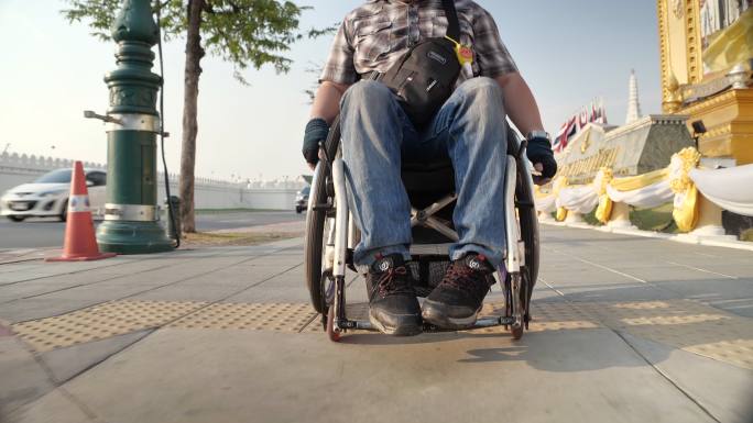 曼谷轮椅旅游地标概念。残疾人过街，轮椅在城市人行道上