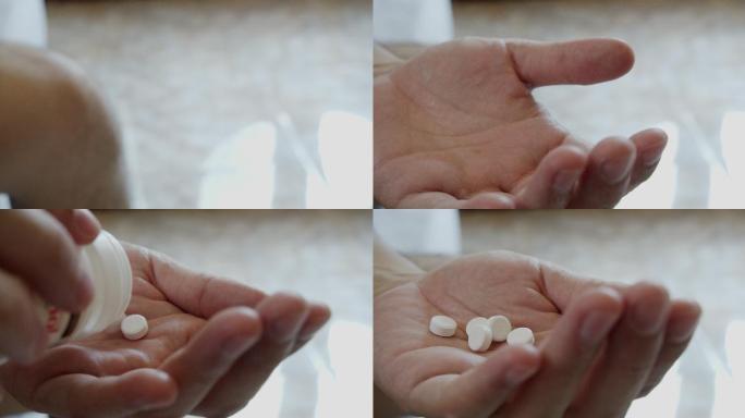 一名亚洲男子正在服用手中的白色药物。