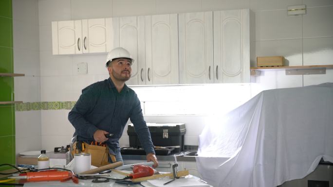 勤杂工检查家庭装修项目厨房的灯具安装