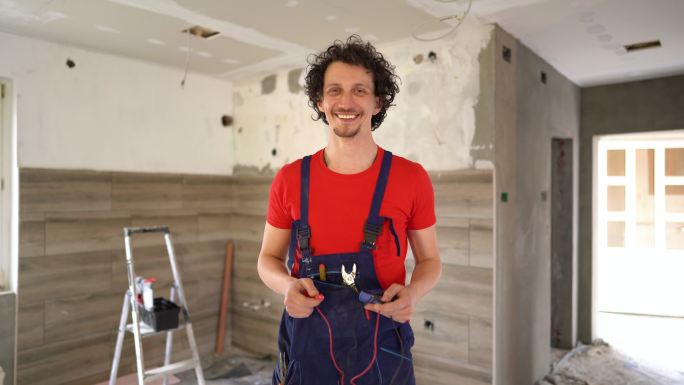 一位微笑的电工整修房屋的画像