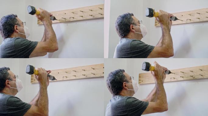 在自己的房子里，为了厨房改造，在墙上拧上一块木头的特写镜头