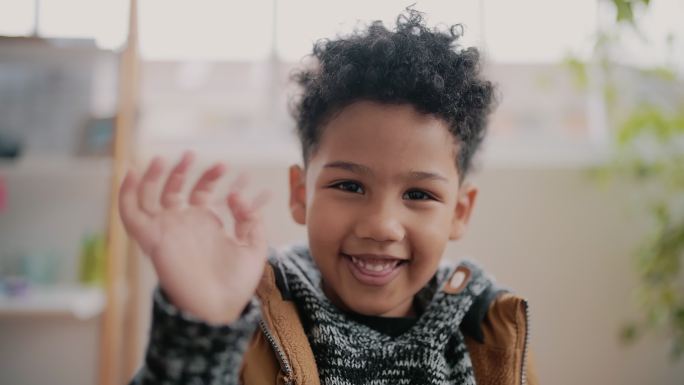 一个可爱的小男孩在家里的视频通话中挥手的4k视频片段