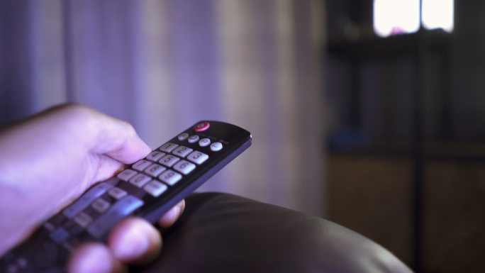 男子换手频道特写遥控器