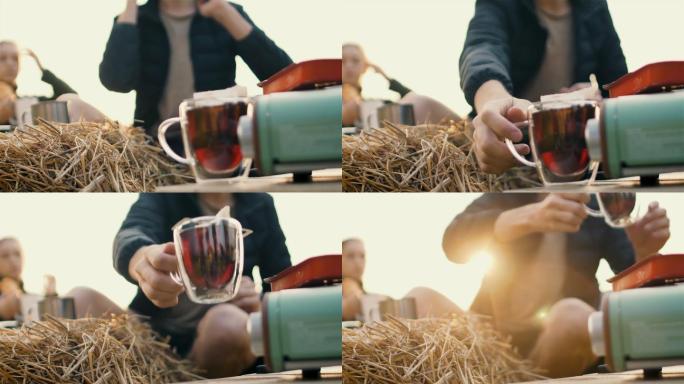 美丽的年轻高加索白人夫妇在日出时分享受野餐。咖啡壶、咖啡杯、茶杯、煎蛋锅、炉子上、野餐的特写镜头。
