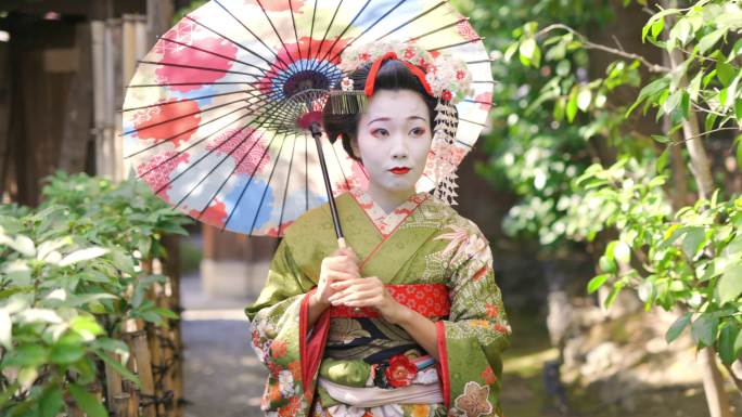 Maiko（艺妓在训练）在京都Gion的狭窄人行道上行走