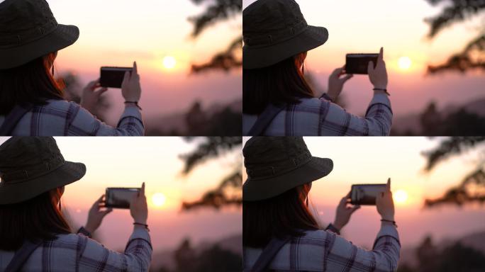 女旅行者在山上日落的好地方拍照