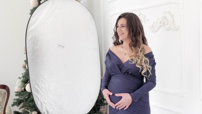 摄影棚里一位孕妇的照片。在工作室拍摄孕妇的后台照片。