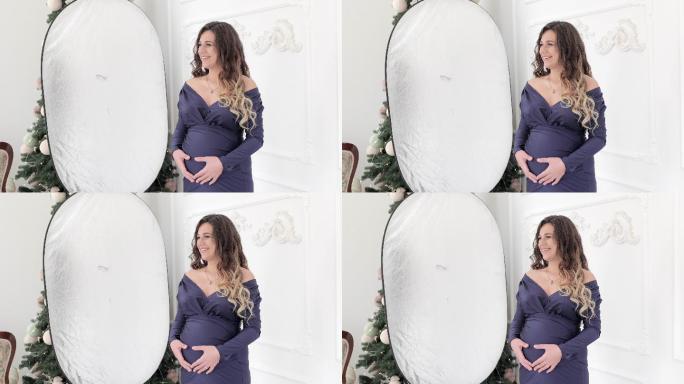 摄影棚里一位孕妇的照片。在工作室拍摄孕妇的后台照片。