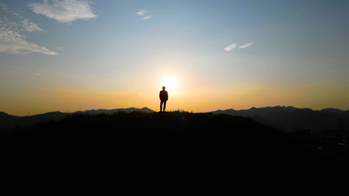 男人登山登顶希望曙光山峰光明拥抱理想未来