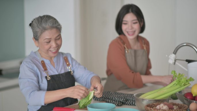 中国亚裔美女和母亲在厨房柜台为家人做饭