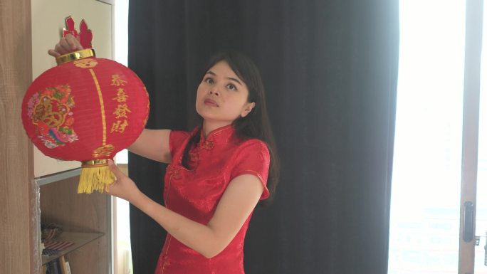 美丽的亚洲年轻女子为中国新年装饰她的房子