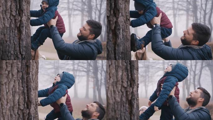 爸爸妈妈在公园里帮助儿子爬树