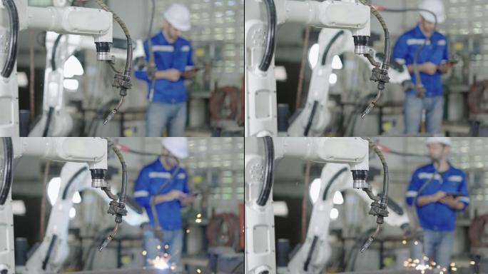 智能工厂工业中的年轻男性工程师检查和控制焊接机器人自动臂机。机器人、科学技术、工业、自动化、机器人概