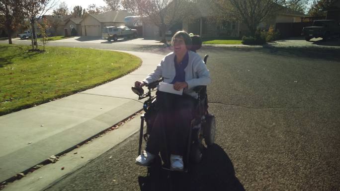轮椅上的成年残疾女性往返邻里邮箱4K视频系列