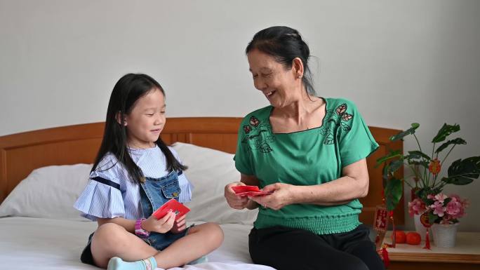 亚洲孙女在农历新年期间在卧室迎接并收到祖母的农历新年红包