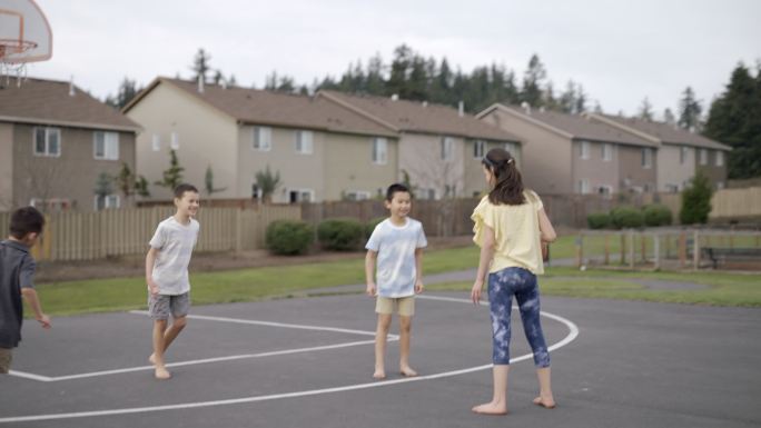 一群小学生在公园户外玩篮球游戏